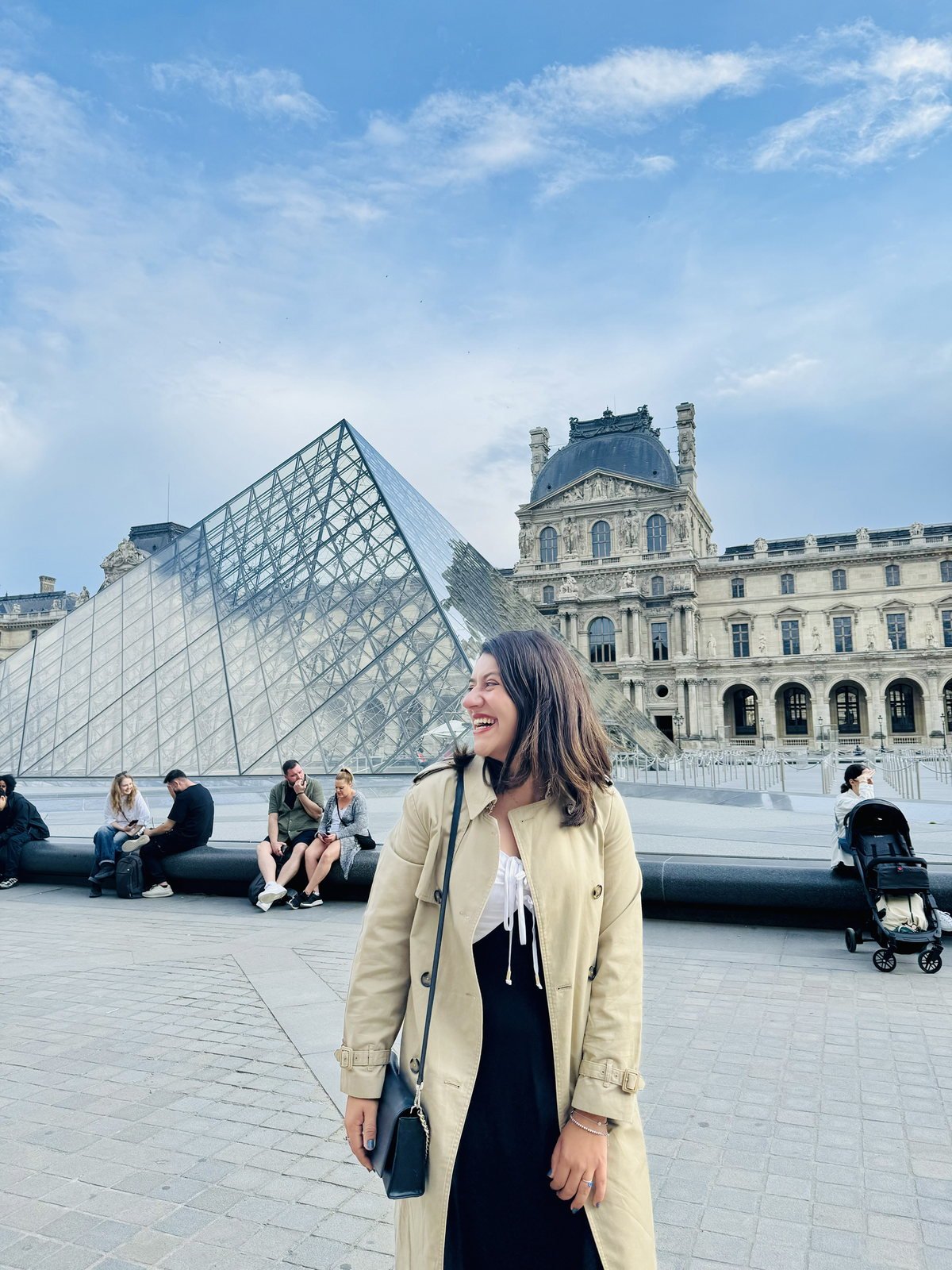 Mari em frente à pirâmide do Louvre